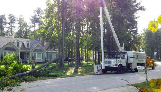 Emergency tree service using bucket truck to remove a storm-damaged tree